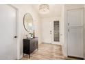 Stylish entryway with wood floors, modern light fixture, and decorative mirror at 9265 E Kalil Dr, Scottsdale, AZ 85260