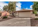 Suburban home with a two-car garage and low-maintenance desert landscaping at 9265 E Kalil Dr, Scottsdale, AZ 85260