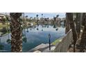 Scenic waterfront view from the property, reflecting the blue sky, surrounded by palm trees and lush landscaping at 10175 E Cochise Dr, Scottsdale, AZ 85258