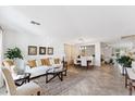 Bright living room featuring tile flooring, a comfortable white sofa and coordinated dining space at 1821 E Patrick Ln, Phoenix, AZ 85024