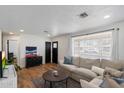 Bright living room featuring hardwood floors, a comfortable couch, and natural light at 2223 E Roma Ave, Phoenix, AZ 85016