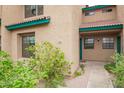 Close-up of townhome exterior showing stucco and tiled roof detail at 225 W 1St St # 107, Mesa, AZ 85201