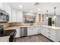 Well-lit kitchen features stainless steel appliances, white cabinetry, stylish countertops, and wood-look flooring at 3444 E Flamingo Ct, Gilbert, AZ 85297