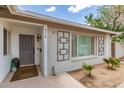 Inviting front entrance showcasing a gray painted door, decorative wall art, and minimalist landscaping at 4410 S Grandview Ave, Tempe, AZ 85282