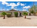 Quaint single-story home with a tidy yard, desert landscaping and mature palm trees, bathed in sunny skies with fluffy clouds at 4410 S Grandview Ave, Tempe, AZ 85282