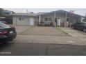 Simple single-story duplex featuring neutral paint, gravel yard, and covered parking at 6010 W Coolidge St, Phoenix, AZ 85033