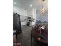 Open-concept kitchen with white cabinets, black appliances, and adjacent dining area at 6010 W Coolidge St, Phoenix, AZ 85033