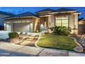 Inviting home exterior showcases a three-car garage, stone accents, and desert landscaping at 6326 W Misty Willow Ln, Glendale, AZ 85310