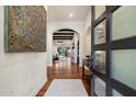 Elegant foyer featuring wood floors, an arched doorway, and a view into the spacious living areas at 7002 E Aster Dr, Scottsdale, AZ 85254