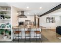 Modern kitchen with stainless steel appliances, light cabinets, breakfast bar, and stylish bar stools at 7326 E Portland St, Scottsdale, AZ 85257