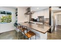 Contemporary kitchen featuring a breakfast bar, modern stainless steel appliances, and natural lighting at 7326 E Portland St, Scottsdale, AZ 85257