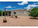 Charming home with a well-maintained yard, gravel landscaping, and a covered parking area at 8330 E Pueblo Ave, Mesa, AZ 85208