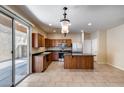 Open-concept kitchen with a kitchen island, stainless steel appliances, and a sliding glass door at 9 N 87Th N Ln, Tolleson, AZ 85353