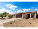 Attractive single-story home featuring a tile roof, gravel landscaping, and a two-car garage at 9332 W Mary Ann Dr, Peoria, AZ 85382