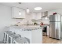 Bright kitchen with white cabinets, stainless steel appliances, granite countertops and barstool seating at 13013 N 18Th St, Phoenix, AZ 85022