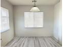 Bright dining area with neutral paint and wood-look flooring, illuminated by a stylish pendant light at 1354 S 228Th Dr, Buckeye, AZ 85326