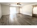 Bright living room featuring wood-look floors and natural light from large windows at 1354 S 228Th Dr, Buckeye, AZ 85326