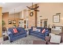 Comfortable living room featuring a stone fireplace, vaulted ceilings, and views into the adjacent dining area at 15827 S 12Th Pl, Phoenix, AZ 85048