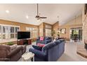 Spacious living room with a vaulted ceiling, ceiling fan, plantation shutters, and comfortable furnishings at 15827 S 12Th Pl, Phoenix, AZ 85048