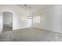 Bright, carpeted living room with an elegant hanging light fixture and vaulted ceilings at 1742 E Chaparral Dr, Casa Grande, AZ 85122