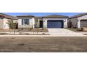 Inviting single-story home with a blue garage door and desert landscaping for low maintenance and appeal at 17545 W Victory St, Goodyear, AZ 85338