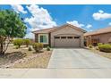 Charming home featuring a two-car garage, a driveway, and desert landscaping, with a stone accent at 19585 W Washington St, Buckeye, AZ 85326