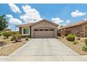 Charming home featuring a two-car garage, a driveway, and desert landscaping, with a stone accent at 19585 W Washington St, Buckeye, AZ 85326