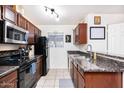 Well-lit kitchen with updated appliances, granite countertops, and tiled floor, maximizing space at 2301 E University Dr # 341, Mesa, AZ 85213
