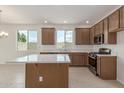 Modern kitchen featuring stainless steel appliances, wooden cabinets, and bright natural light at 25332 N 133Rd Ave, Peoria, AZ 85383