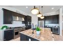 Modern kitchen with granite countertops, stainless steel appliances, and dark cabinets with ample storage space at 26355 N 79Th Dr, Peoria, AZ 85383