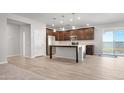 Open-concept kitchen featuring a kitchen island, dark wood cabinets, stainless steel appliances, and tile floors at 2823 N Arroyo Grande Ave, Casa Grande, AZ 85122