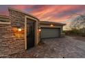 A gated entrance to the home with a brick surround and a paved driveway leading to a two car garage at 3045 W Feather Sound Dr, Phoenix, AZ 85086