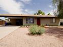 Inviting home featuring an attached carport and low-maintenance landscaping, enhancing curb appeal at 3216 E Campo Bello Dr, Phoenix, AZ 85032