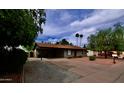 Single-story home with an attached carport, complimented by trees and drought-tolerant landscaping at 3216 E Campo Bello Dr, Phoenix, AZ 85032