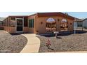 Inviting home exterior with pathway, gravel landscaping, and screened-in porch at 5221 E Mills Ct, Mesa, AZ 85215