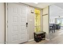 Bright entryway featuring a white front door, sidelight window, seating, coat hooks, and light wood-look flooring at 5224 S Monaco Dr, Tempe, AZ 85283
