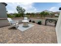 Outdoor patio featuring brick pavers, two white Adirondack chairs with blue pillows, and a white round table at 5633 N 206Th Ave, Buckeye, AZ 85396