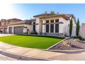A well-maintained single-story home with desert landscaping and a neatly manicured artificial lawn at 6518 W Louise Dr, Glendale, AZ 85310