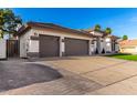 A three-car garage with a paved driveway and a view of the home's facade is displayed at 6518 W Louise Dr, Glendale, AZ 85310