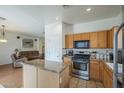 Well-lit kitchen featuring an island, stainless steel appliances, and convenient access to living area at 7937 W Chickasaw St, Phoenix, AZ 85043