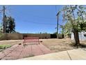 Expansive backyard showcasing a patio, vibrant red bench, mature tree, and block fence, offering a private retreat at 8502 N 26Th Ave, Phoenix, AZ 85021