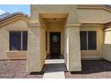 Inviting front entry with decorative wreath and sheltered porch leading into the home at 11746 W Camino Vivaz --, Sun City, AZ 85373