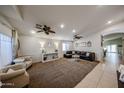 Spacious living room with plush carpeting, ceiling fans, and abundant natural light at 11746 W Camino Vivaz --, Sun City, AZ 85373