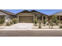 Single-story home featuring a two-car garage, desert landscaping, and a concrete driveway at 15018 W Buckskin Trl, Surprise, AZ 85387