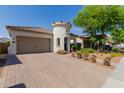Charming single-story home with a turret entrance, attached two-car garage, well-maintained landscaping and a brick driveway at 20556 W Point Ridge Rd, Buckeye, AZ 85396
