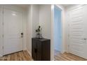 Clean entryway featuring a white door, wood-look floors, and a contemporary storage cabinet at 21303 E Estrella Rd, Queen Creek, AZ 85142