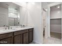 Bathroom featuring double sinks, marble counters, and a glass enclosed shower, providing a spa-like experience at 25096 N 154Th Ln, Surprise, AZ 85387