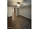 Bedroom with wood-look flooring, ceiling fan, closet with sliding doors, and neutral walls at 4049 N 81St Ave, Phoenix, AZ 85033