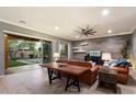 Cozy living room with a decorative accent wall, comfortable leather furniture, and a seamless transition to the outdoor patio at 5123 S Mariposa Dr, Gilbert, AZ 85298