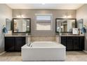 Serene main bathroom with a luxurious soaking tub, double vanities, and elegant fixtures at 5123 S Mariposa Dr, Gilbert, AZ 85298